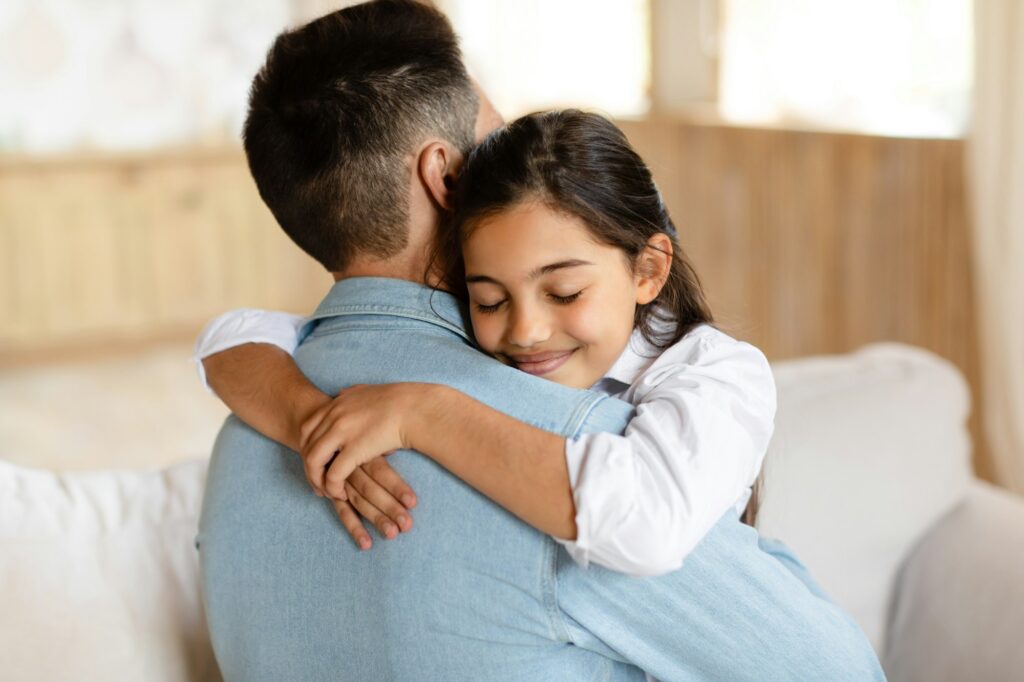 Portrait of daddy and daughter at home, girl hugging dad